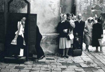 Black and white photograph of a long line for conefession outside a Church